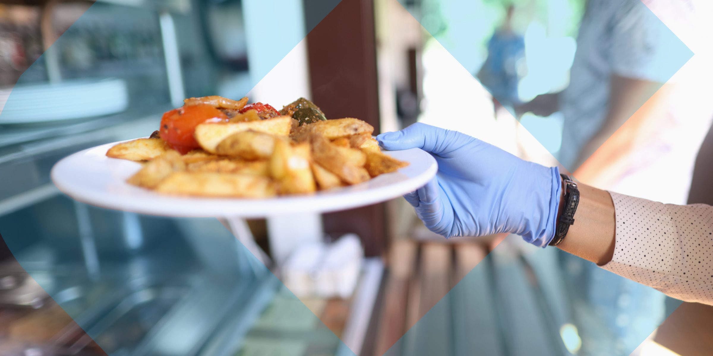 a hand holding a meal on a plate with the college logo in the background.