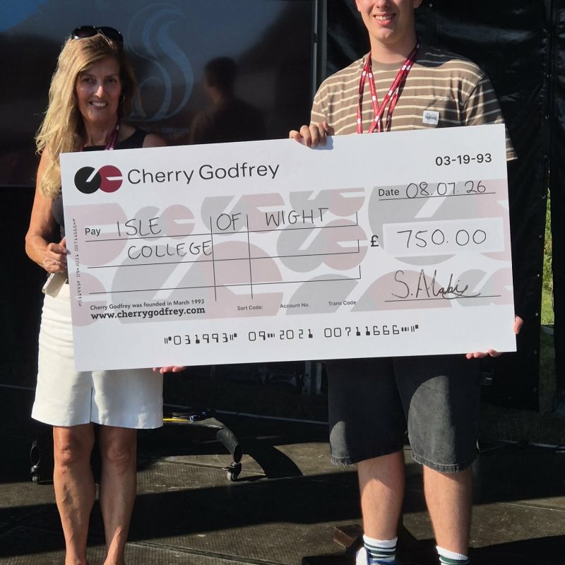 Student and Lecturer holding a signed cheque made out to the college for £750