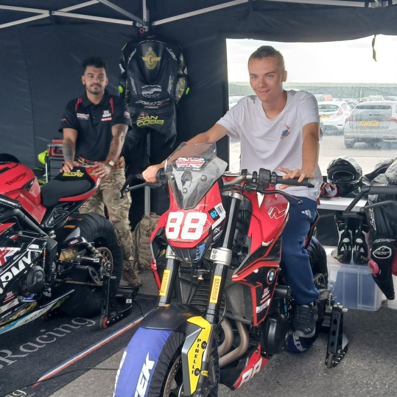 a Student poses on a Race motorcycle