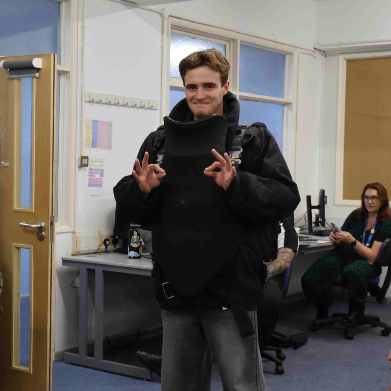 Student Poses for the camera wearing a bomb disposal suit