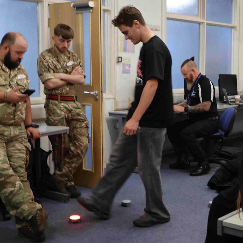 A student tests his reflex by stepping on flashing lights on the floor