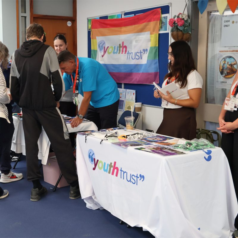 Students gather and look at the Youth Trust Stall.