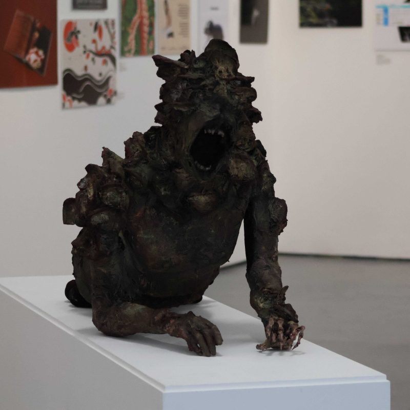 A Sculpture of a monster is displayed across a table.