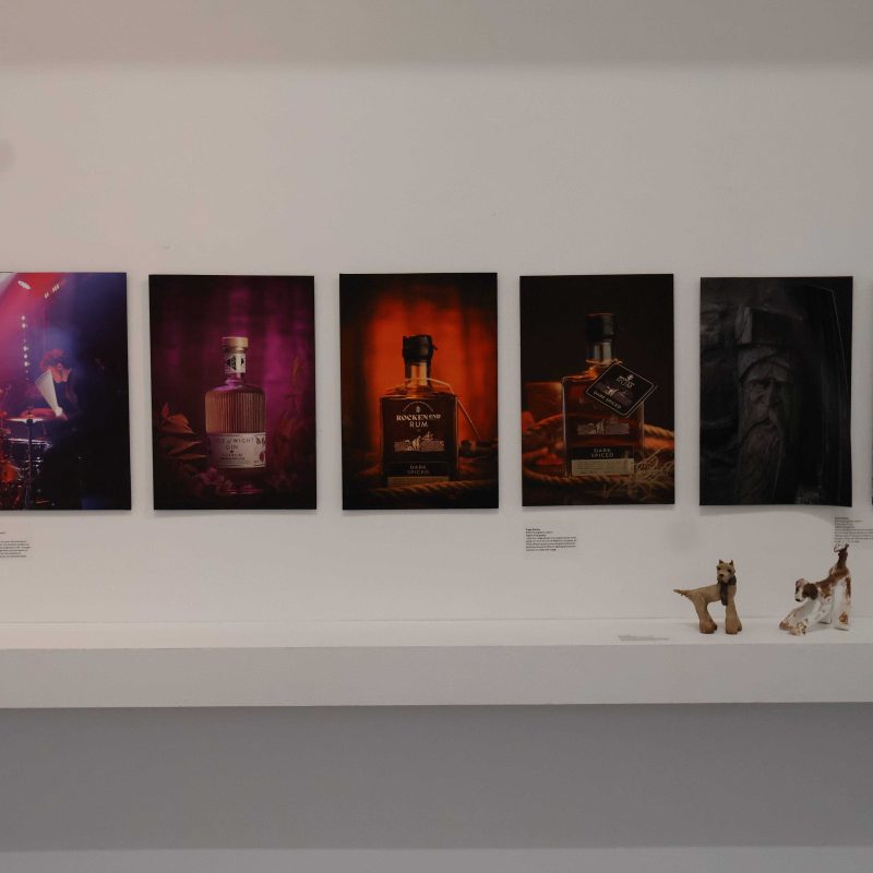 Various photography artwork is displayed on a wall