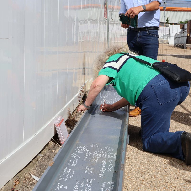 a woman signs the steel beam
