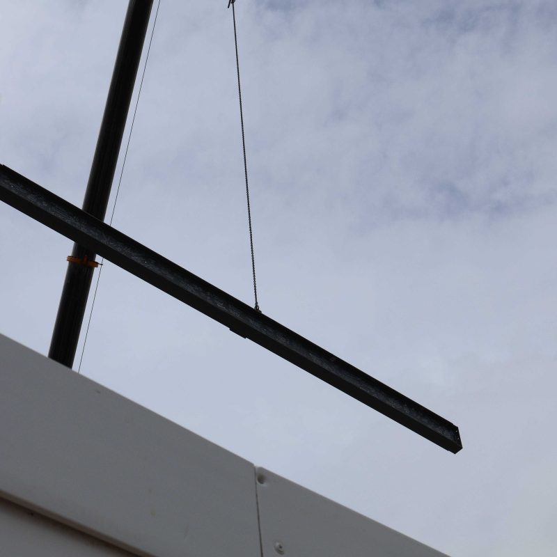 The steel beam being lifted into the air by a crane