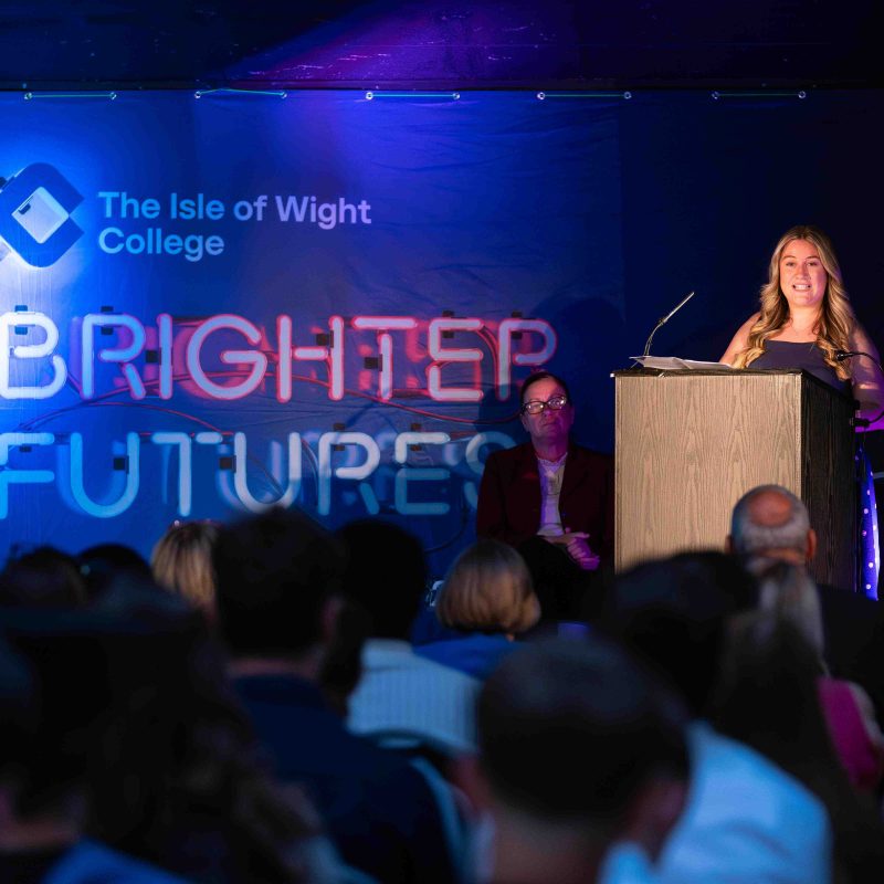 A woman addresses a large crowd from the stage