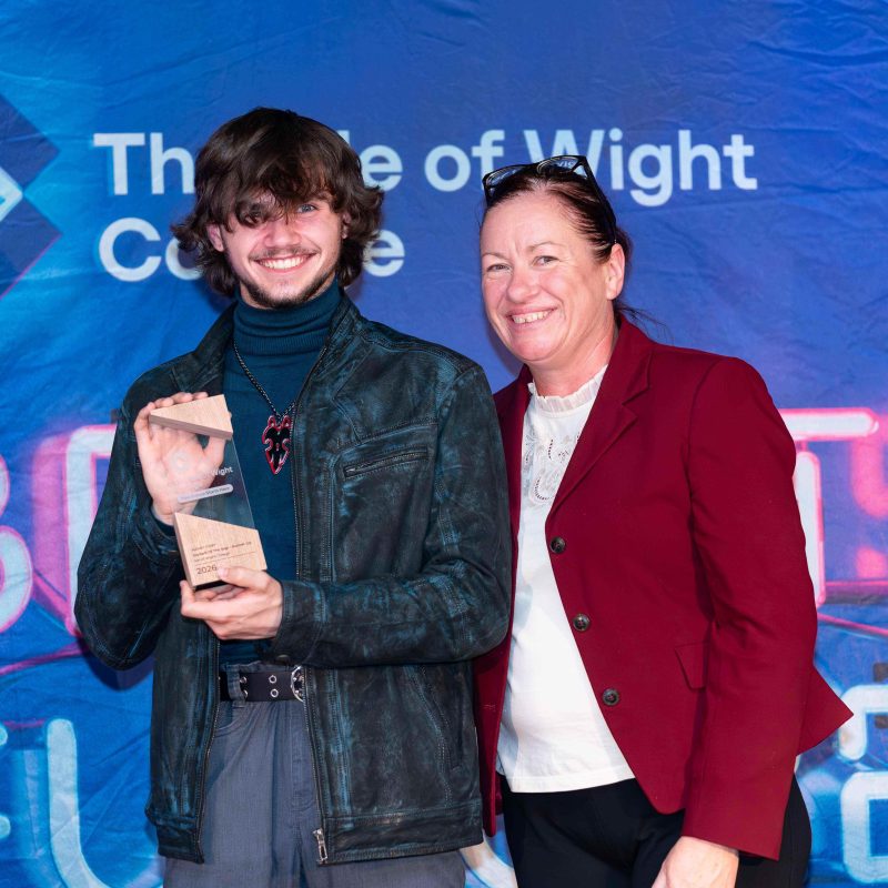 A student receives his award and poses with the principal