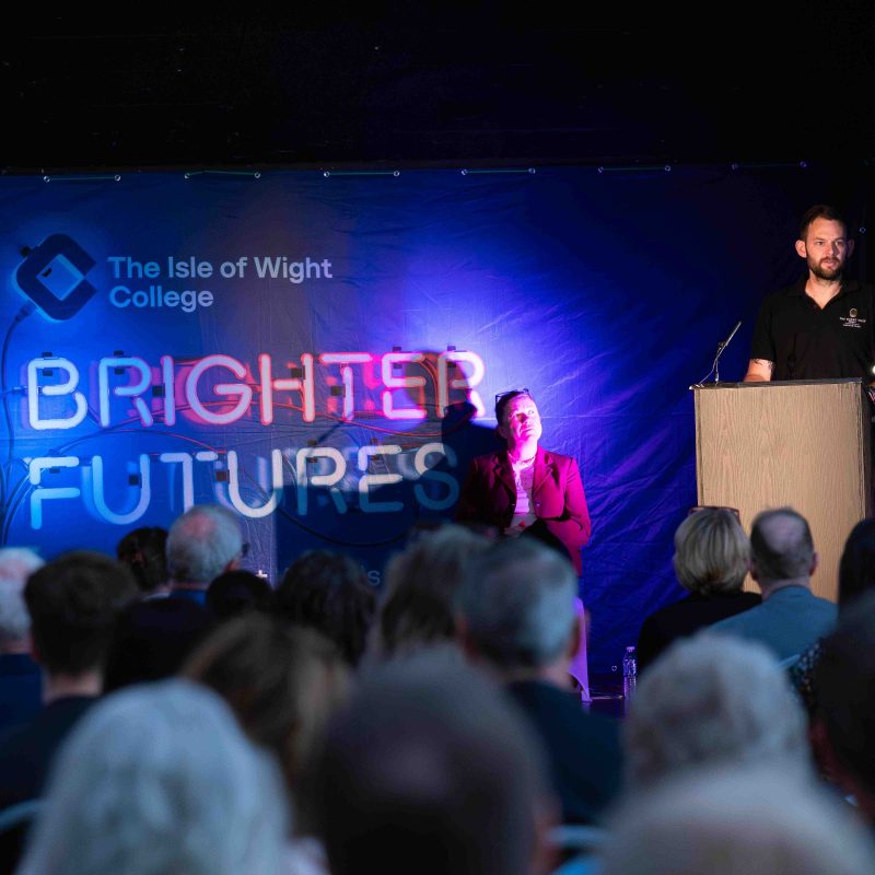 a man addresses the crowd from the stage
