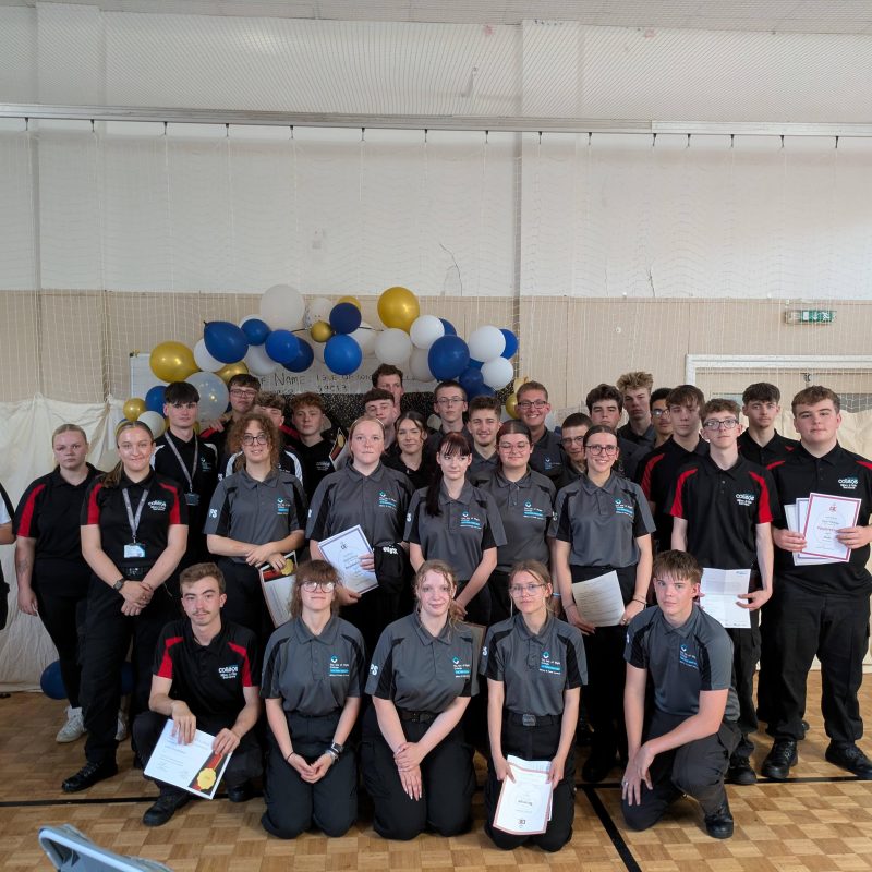 a large group of students pose for a group photo in a hall
