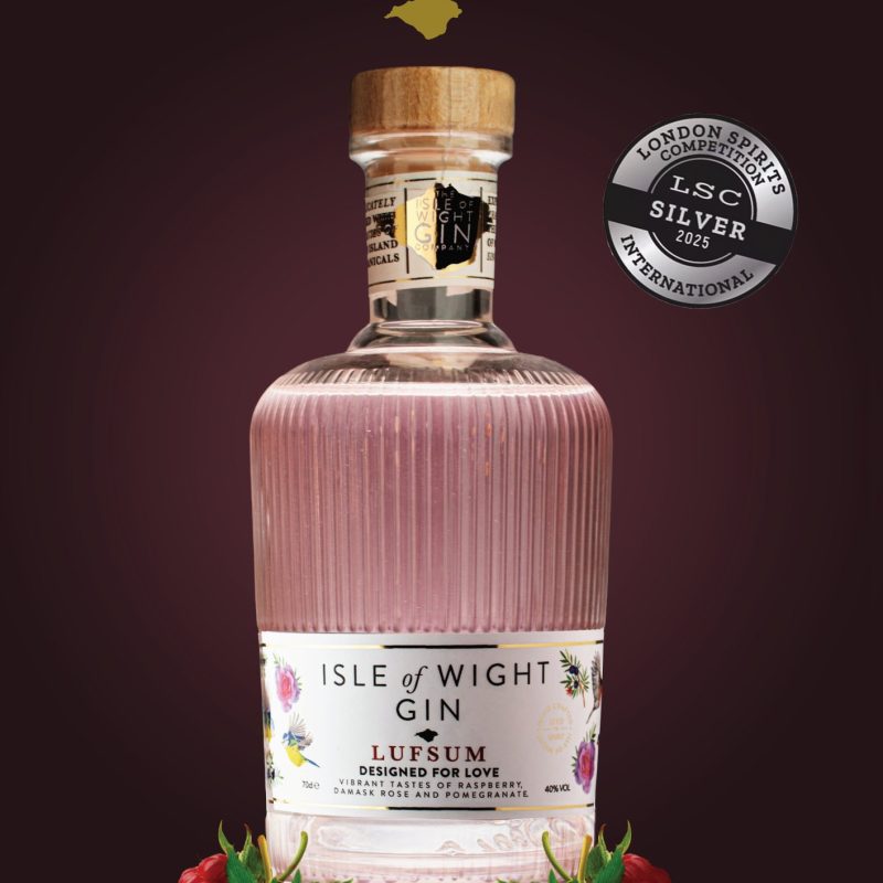 an advert depicting a gin bottle on a dark velvet purple background with the isle of wight gin logo at the top.