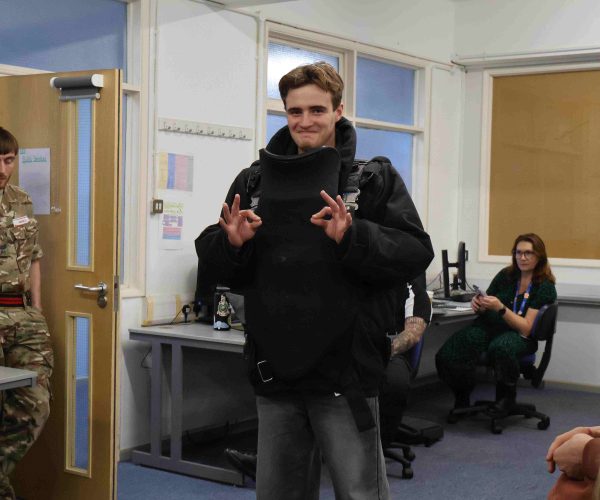 Student Poses for the camera wearing a bomb disposal suit