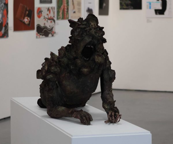 A Sculpture of a monster is displayed across a table.