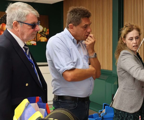 Two councillors are being shown something on a piece of paper
