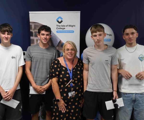 Group of male students stand beside their female lecturer with their results