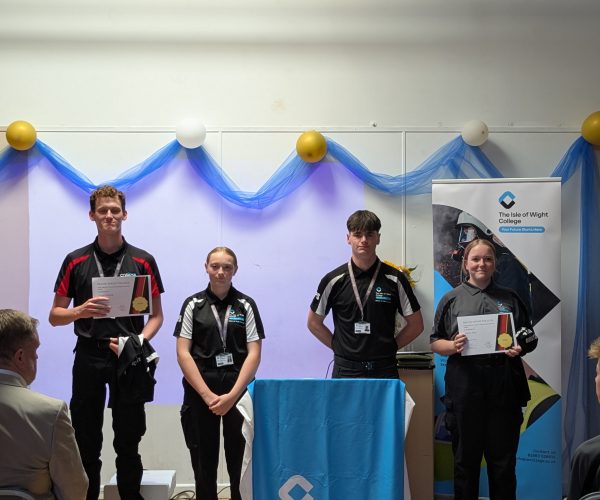 students stand at the front of the hall and pose with their certificates