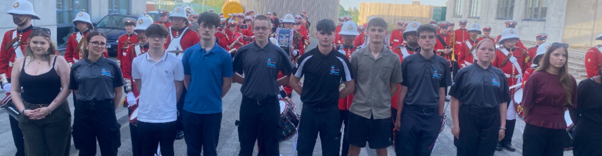 Public Services Student Stand at attention in front of medina marching band.