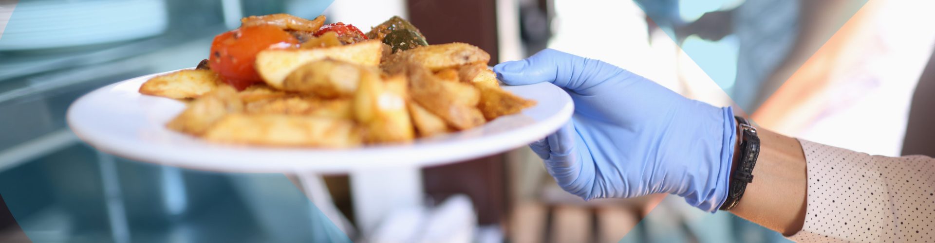 a hand holding a meal on a plate with the college logo in the background.